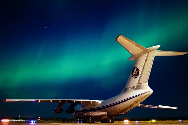 A huge plane on the background of the night sky with a beautiful sunset