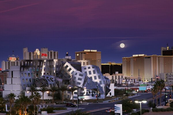 The moon in the purple sky over the city