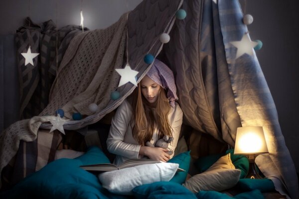 Fille assise sur le lit avec un livre