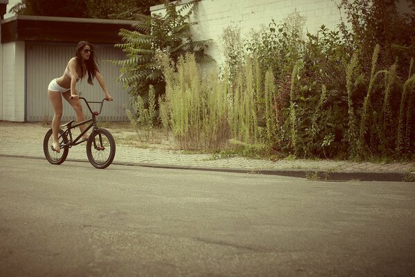 Fille en lingerie chevauche un vélo