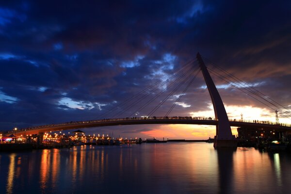 Puente de Taipei sobre el río en el fondo del cielo nocturno