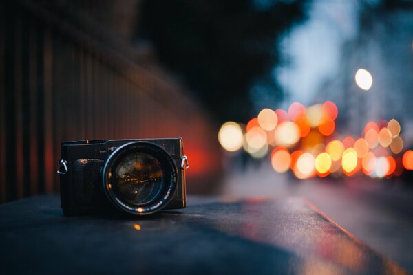 Appareil photo sur fond de crépuscule de la ville et des lumières