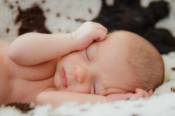 The baby sleeps sweetly on a warm blanket