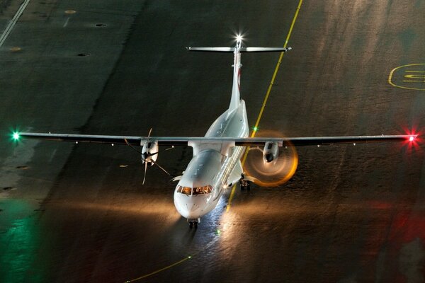 Flugzeug mit brennenden Lichtern auf dem Flugplatz in der Nacht