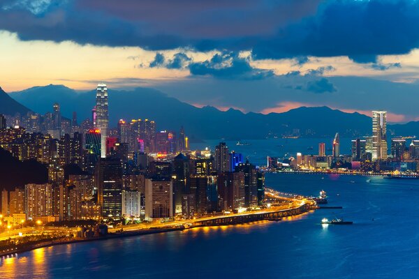 Paseo marítimo iluminado al atardecer en Hong Kong