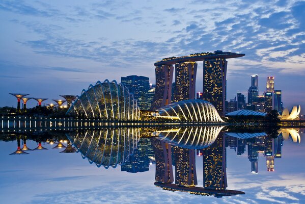 Das abendliche Singapur spiegelt sich im Wasser in hellen Lichtern wider