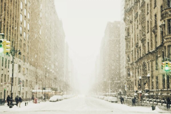 A snow-covered street of a big city in a fog