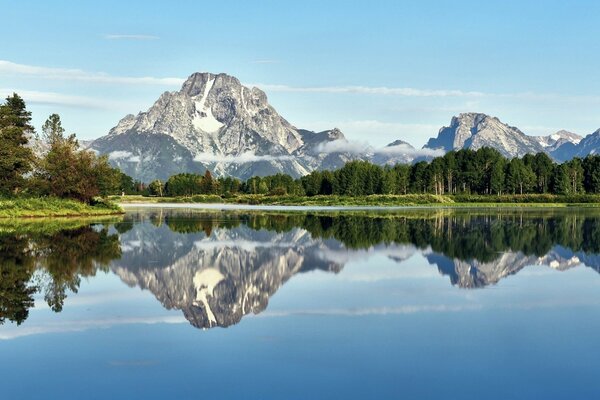 Daytime lake with mountain reflection