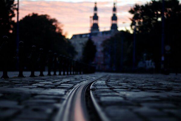 Night street in gray tones under a pink sunset sky