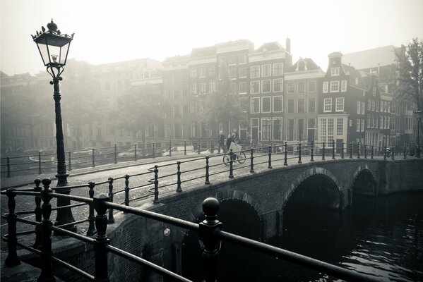 Fiume, ponte, lanterna, città vecchia nella nebbia