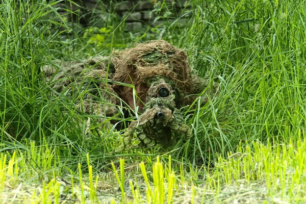 Sniper assis dans une embuscade en camouflage