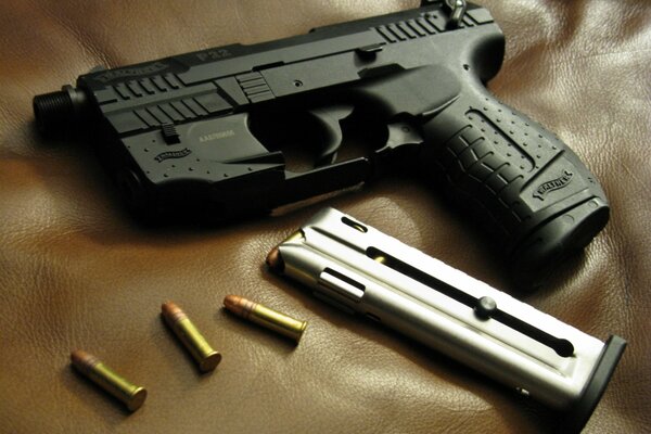 Photo of a Walther pistol with cartridges on a brown leather background