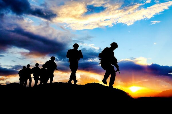 Silhouetten von Soldaten bei Sonnenuntergang