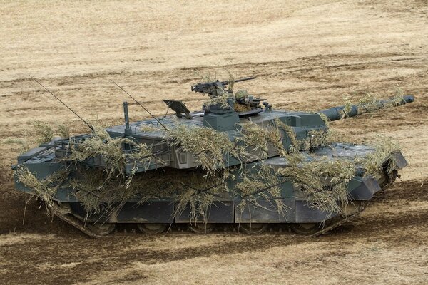 Замаскированый военный танк на поле