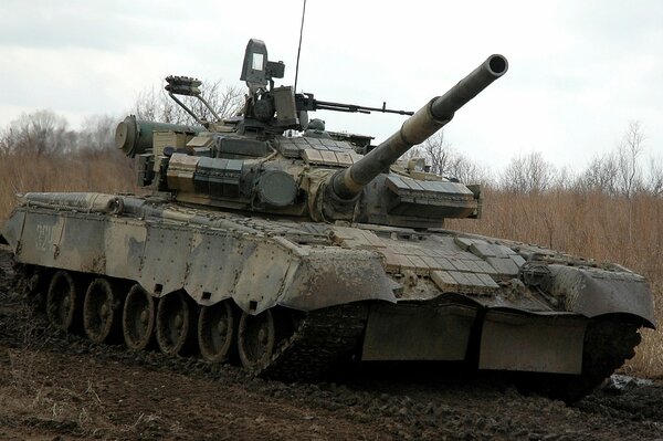 Un char militaire roule sur une route boueuse