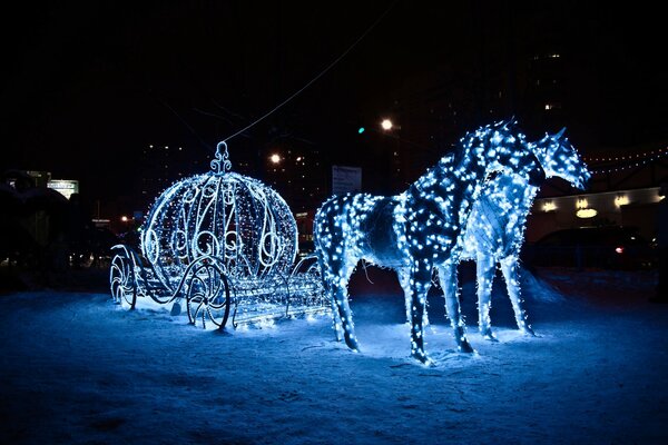Лошади и карета из гирлянд в снегу