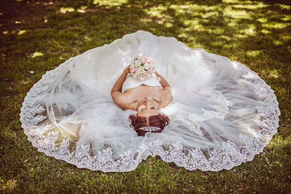 La novia en un vestido sostiene un ramo