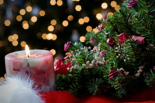 Vela encendida junto al árbol de Navidad decorado