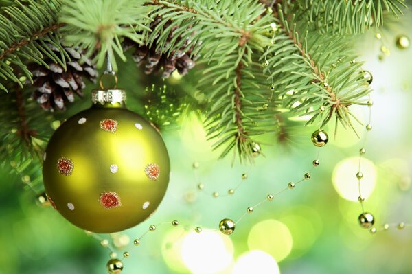 Fir twigs with cones with a golden ball and beads