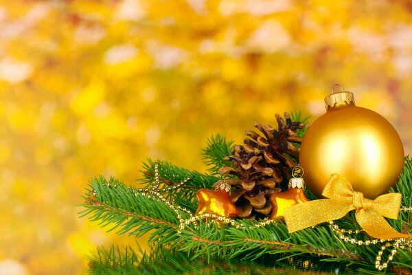 Boule de Noël dorée et pomme de pin sur le pied de l arbre de Noël