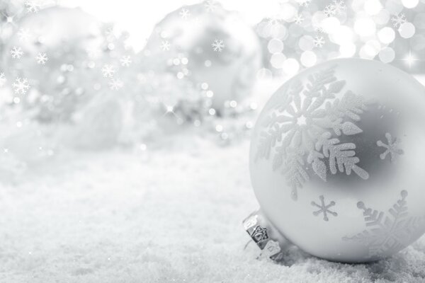 Festliches, silbernes Spielzeug auf einem Hintergrund von Schneeflocken