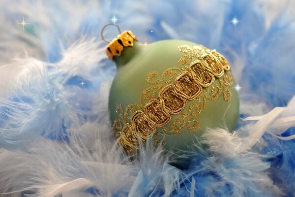 Christmas ball with golden patterns on white and blue feathers