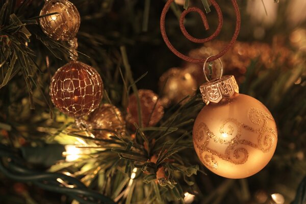 Brillantes decoraciones de Navidad de oro en el árbol de Navidad