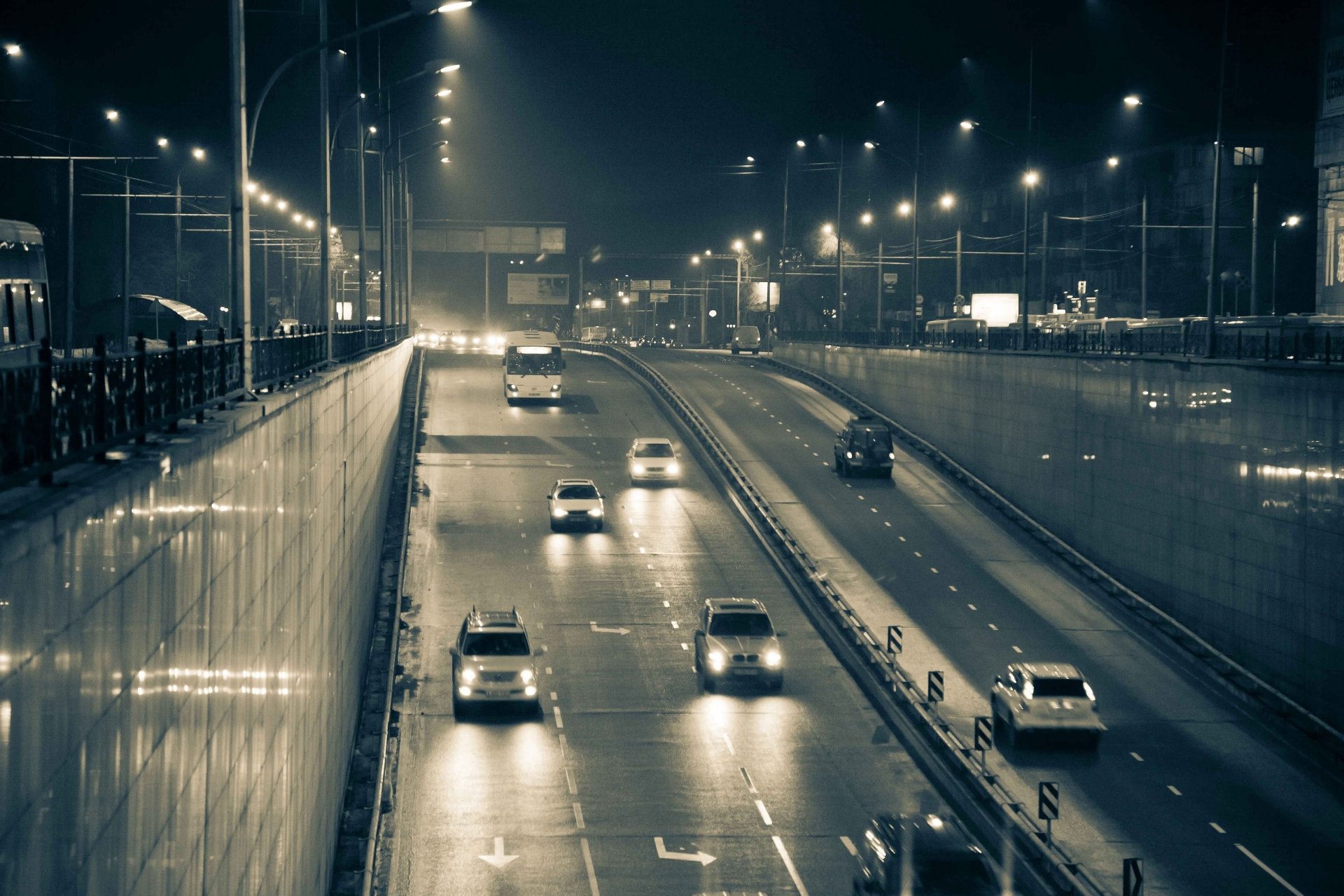 ciudad noche entrada al túnel coches luz faros