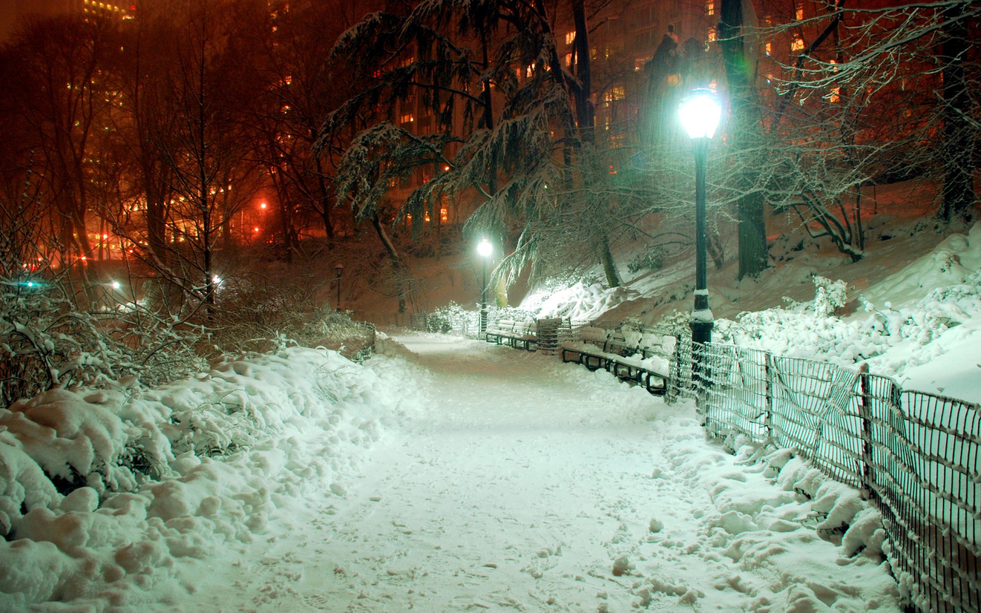 city lantern snow light buildings park evening sidewalk fence tree