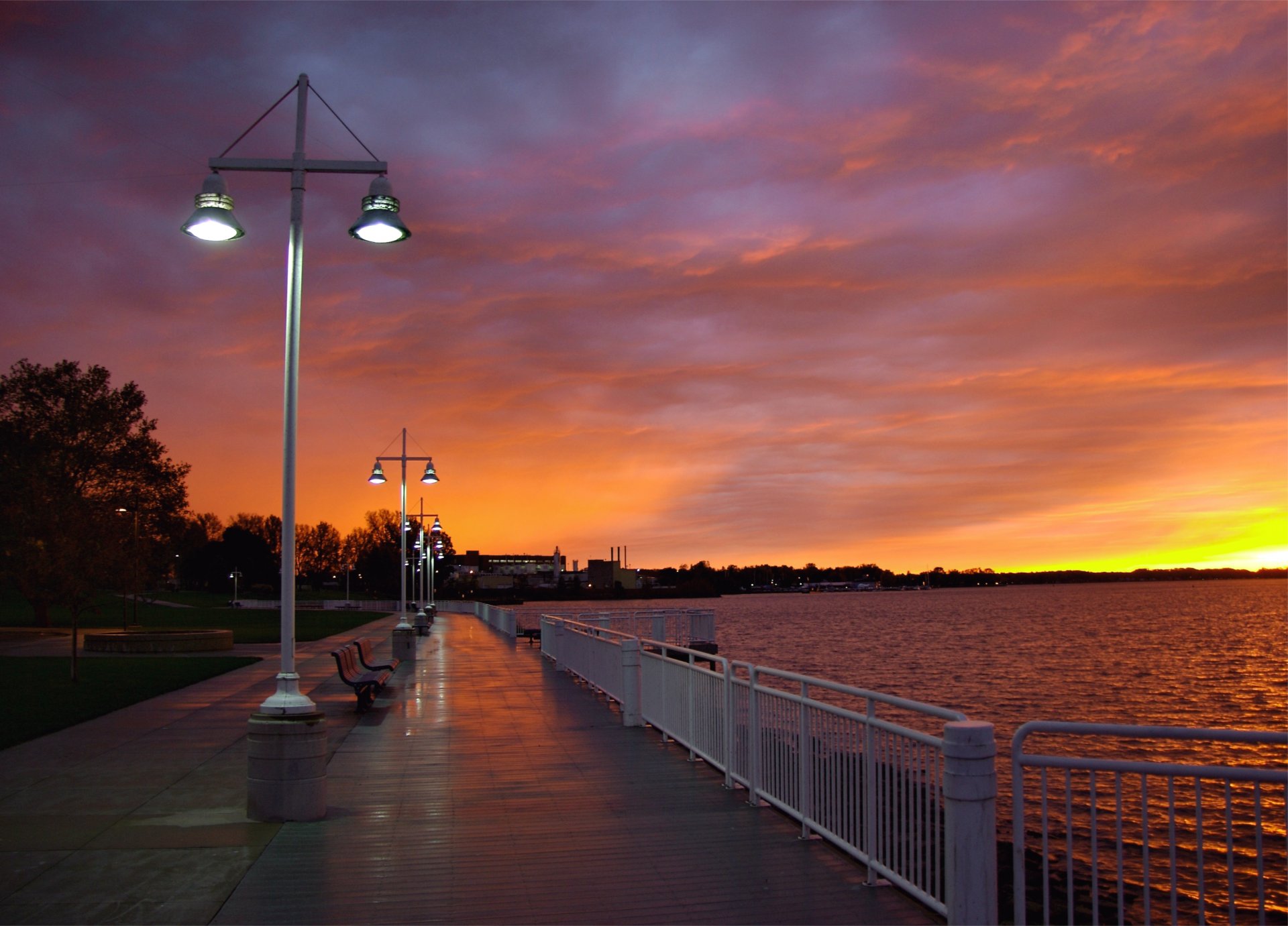 city evening sunset sky clouds clouds embankment trees benches river lanterns light