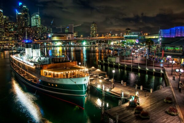 Barco En el muelle en el fondo de la ciudad de la noche