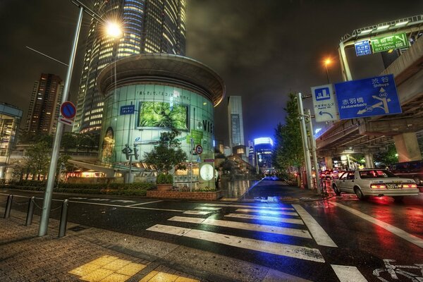 Paso de peatones bajo una linterna por la noche en Japón