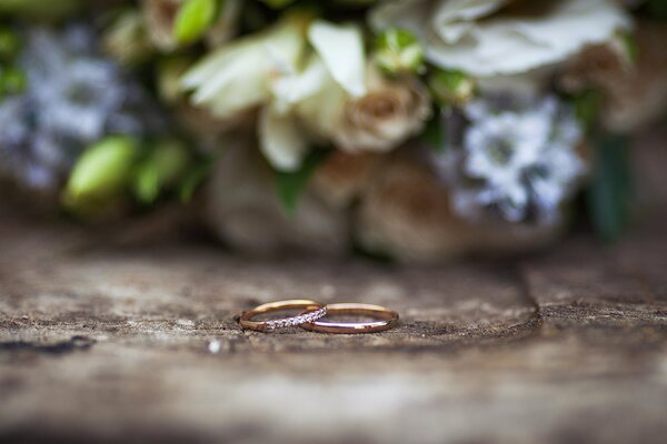 Anillos de boda en el fondo del ramo