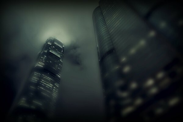 Fog, clouds and skyscrapers with light in the windows