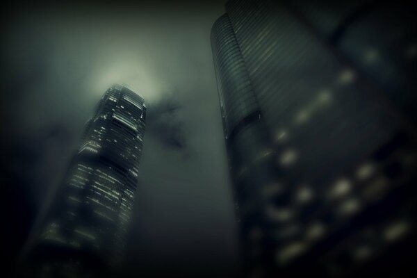 Nebbia, nuvole e grattacieli con luce nelle finestre