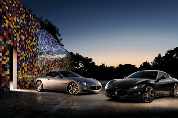Zwei Maserati-Fahrzeuge an der Mosaikwand