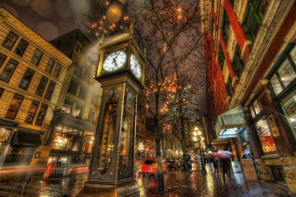 Uhr in der Stadtstraße, Menschen mit Regenschirmen im Regen