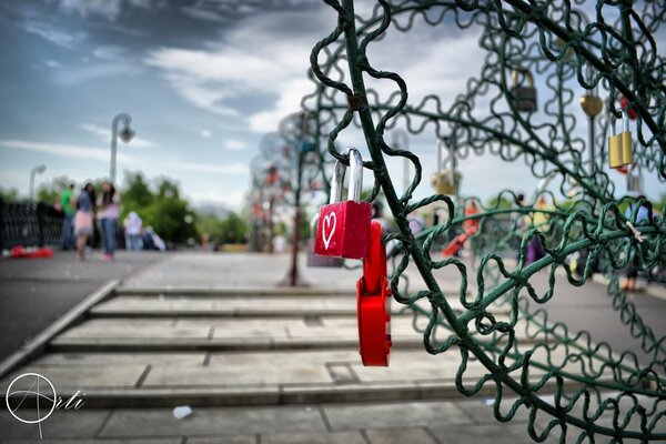 Le serrature rosse con il cuore pendono sul ponte