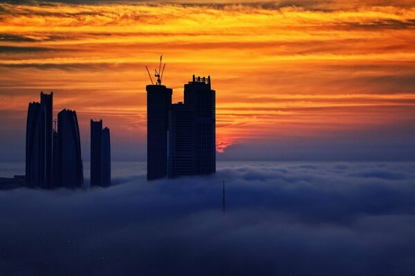 Wolkenkratzer in den Wolken bei Sonnenuntergang des Tages