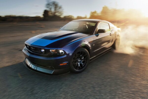 Mustang drifts and blows smoke from under the wheels