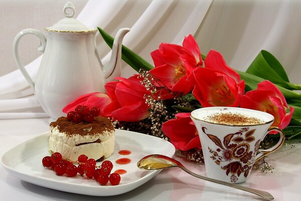 A cup of coffee with a beautiful dessert decorated with berries