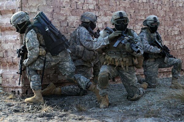 Soldiers with helmets and weapons are hiding around the corner