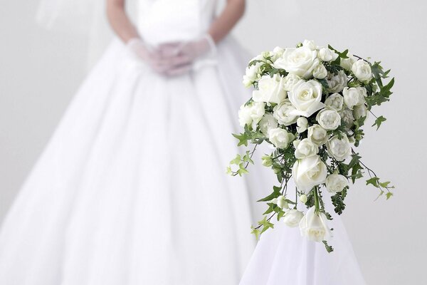 White bouquet of roses on the background of the bride s dress