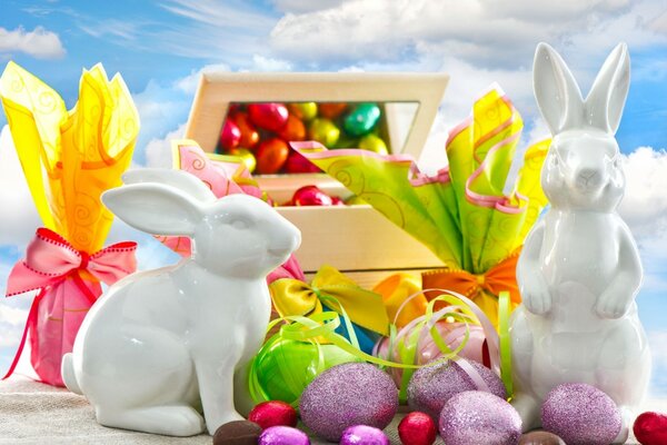 Figuras de conejo blanco con huevos de Pascua