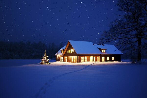 Cozy house in the middle of a snow-covered field on New Year s Eve