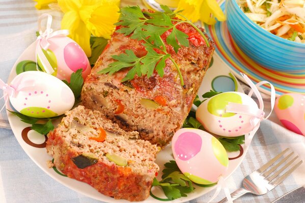 Easter eggs and a roll on a platter decorated with a sprig of parsley