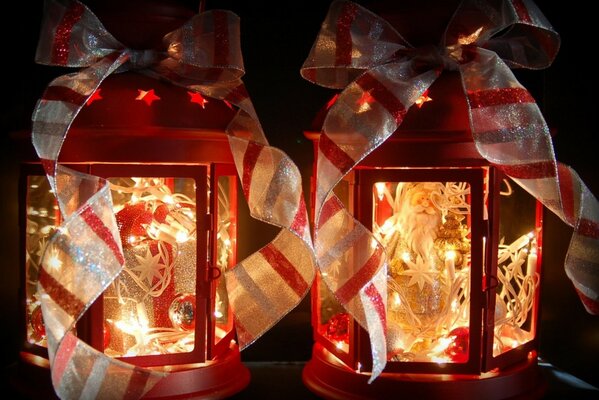 Red burning Christmas lanterns with decorations in the form of striped ribbons