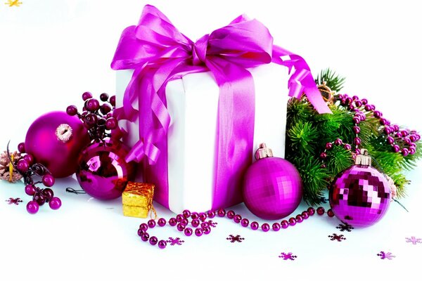 Gift box with purple bow surrounded by Christmas decorations