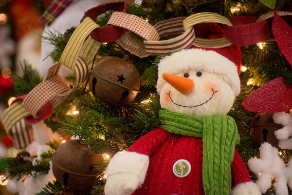 Pupazzo di neve sullo sfondo di un albero di Natale con giocattoli