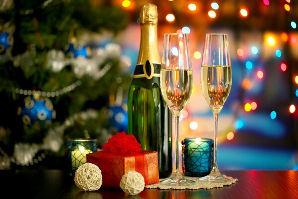 Champán en la mesa de año nuevo junto al árbol de Navidad